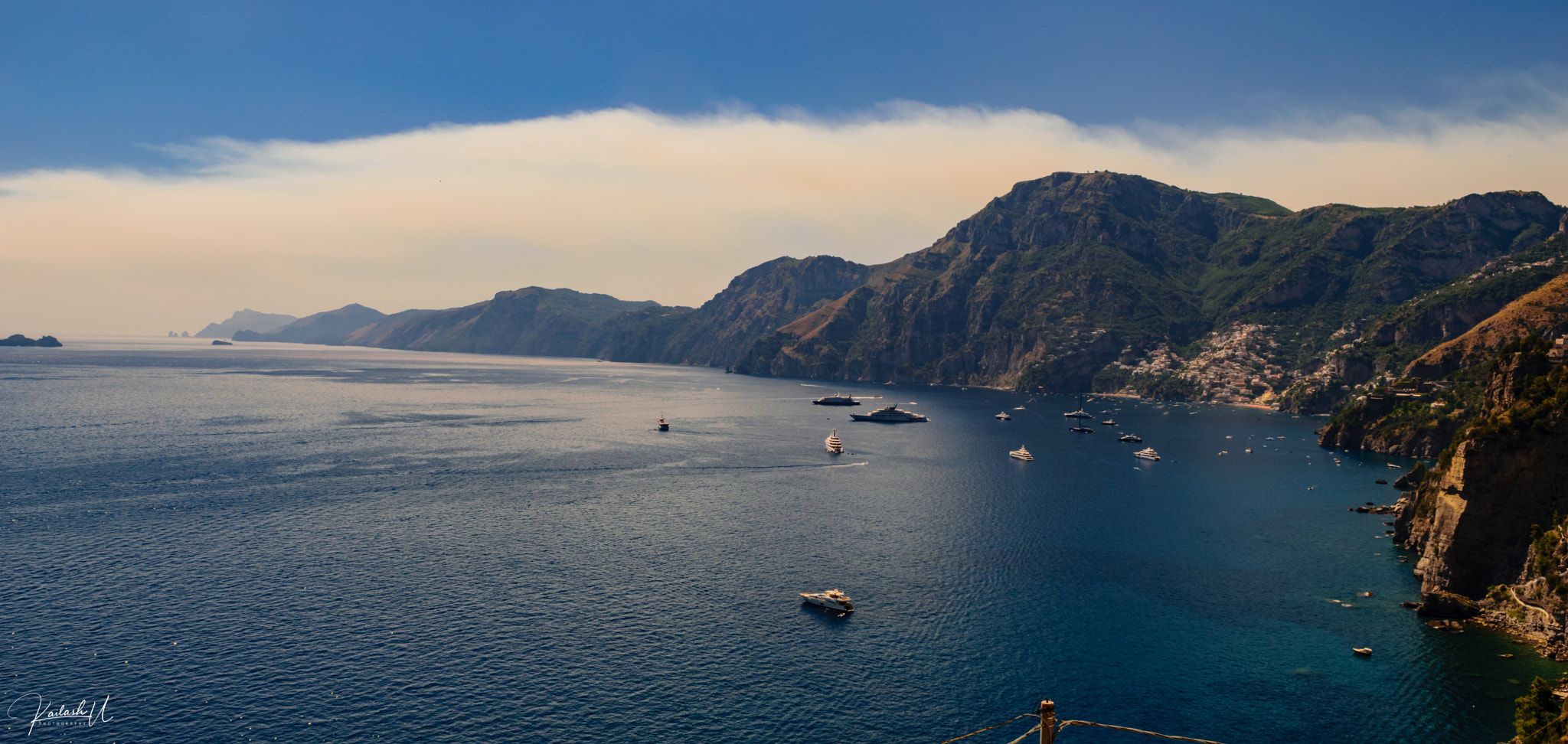 Boats on the blue water below the cliffs of the Amalfi Coast