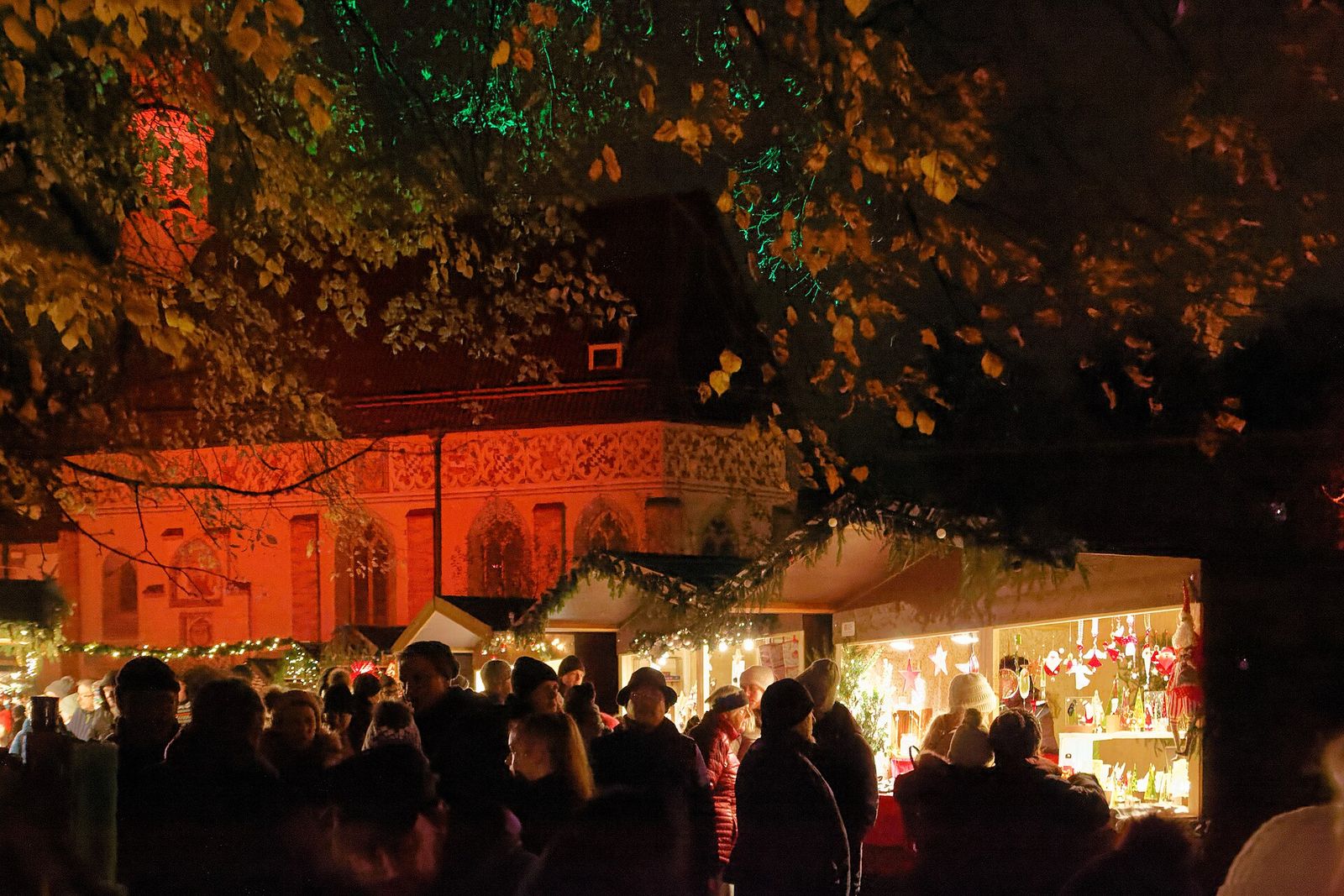 A Christmas market stall glowing under the trees