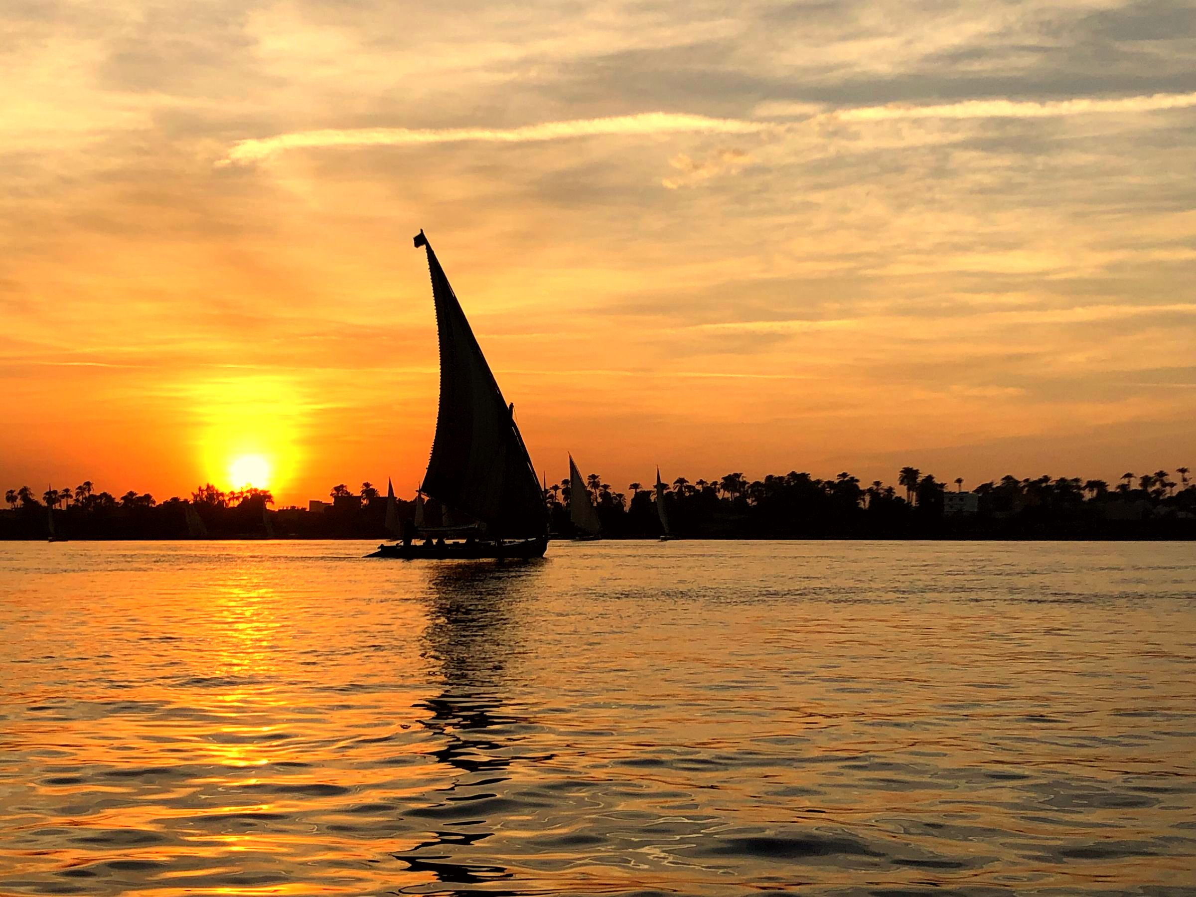 A felucca under sail on the Nile at sunset